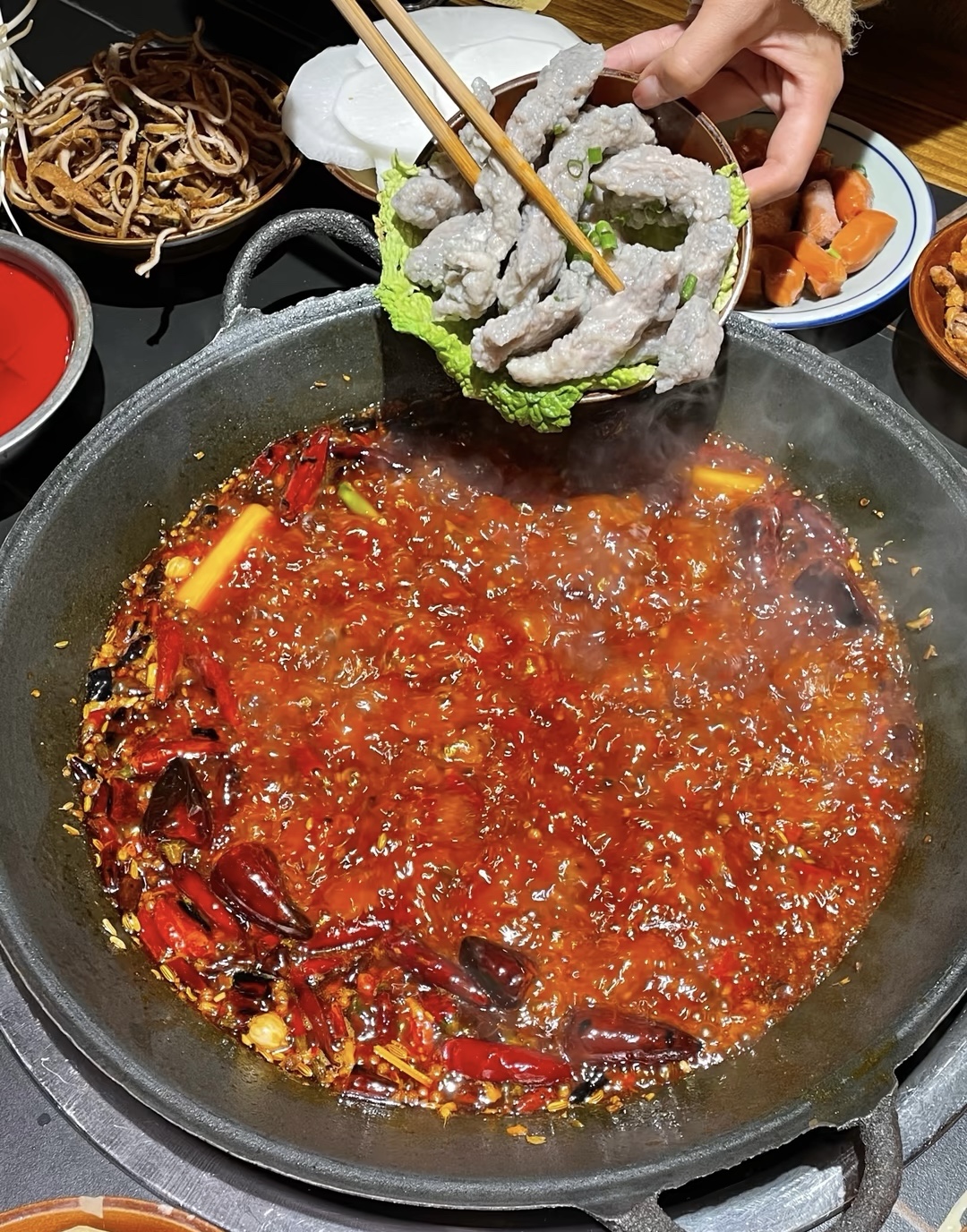 四川的火锅远近闻名锅底热气腾腾，锅中食材 配图3