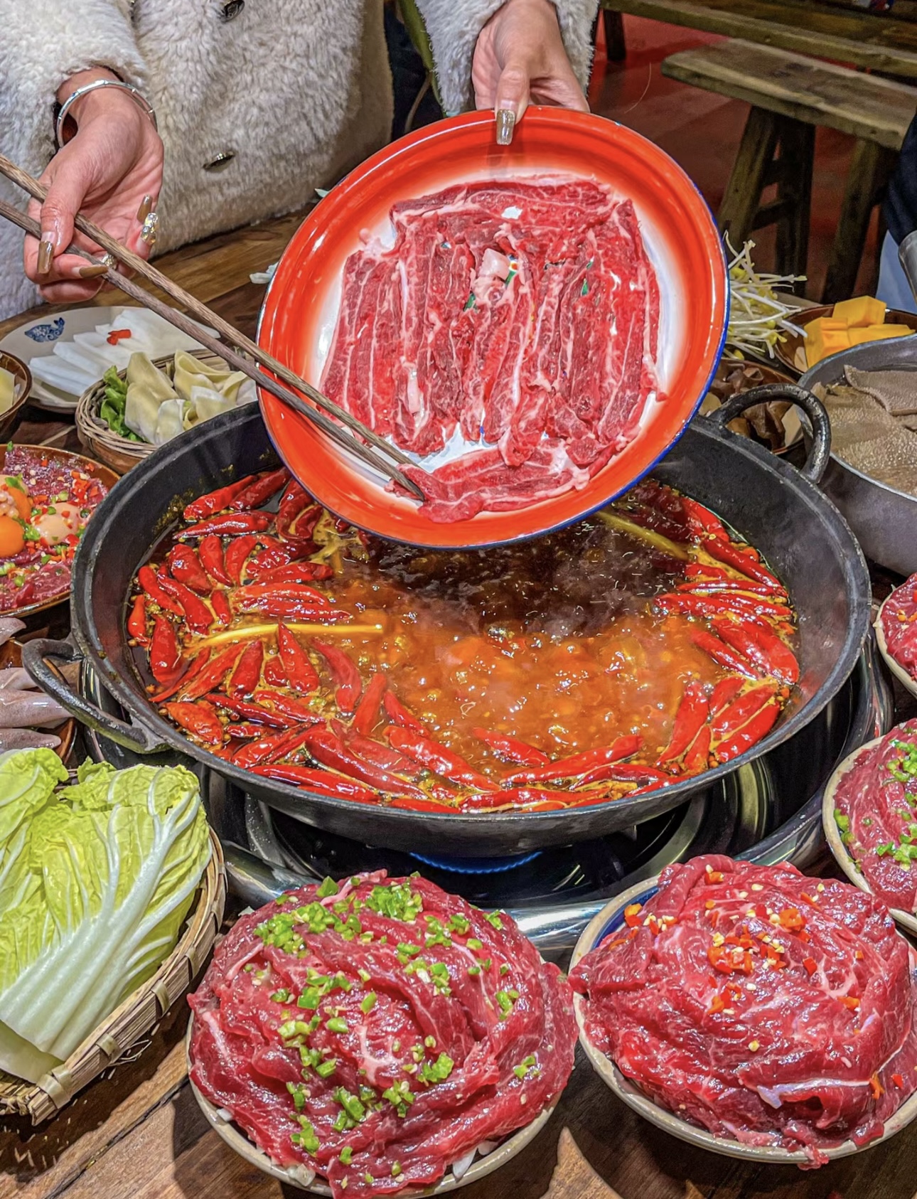 一锅红油，翻滚着麻辣鲜香。火锅店中，美味 配图1